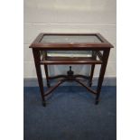 A MAHOGANY BIJOUTERIE TABLE, with bevelled edge glass lid enclosing a mirrored interior, on square