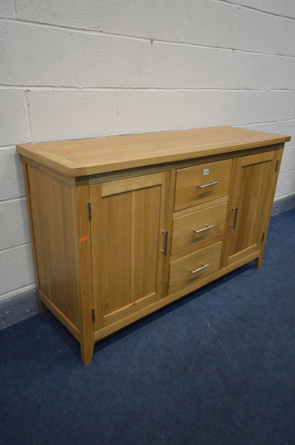 A SOLID OAK SIDEBOARD with two doors flanking three drawers, width 137cm x depth 47cm x 85cm ( - Image 2 of 2