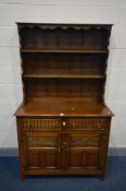 A REPRODUCTION OAK DRESSER with two drawers above two carved and fielded cupboard doors, width 107cm