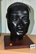 A LATE 20TH CENTURY BLACK GLAZED PLASTER BUST OF AN AFRICAN WOMAN, mounted on a square wooden