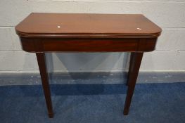 A GEORGIAN MAHOGANY FOLD OVER TEA TABLE with rounded and reeded edges on square tapering legs