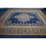 A LARGE WOOLLEN KERMAN CARPET, gold foliate with blue ground, 405cm x 299cm (condition - central