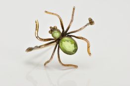 A YELLOW METAL SPIDER BROOCH, set with an oval and a circular cut peridot to the body and head, each