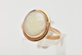 A YELLOW METAL OPAL RING, designed with an oval cut opal cabochon measuring approximately 13.9mm x