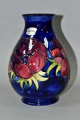 A MOORCROFT POTTERY BALUSTER VASE, decorated with anemone pattern on a dark blue ground, silver