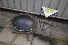 A FIRE PIT with a cylindrical metal frame on shaped legs with bowl insert along with an outdoor