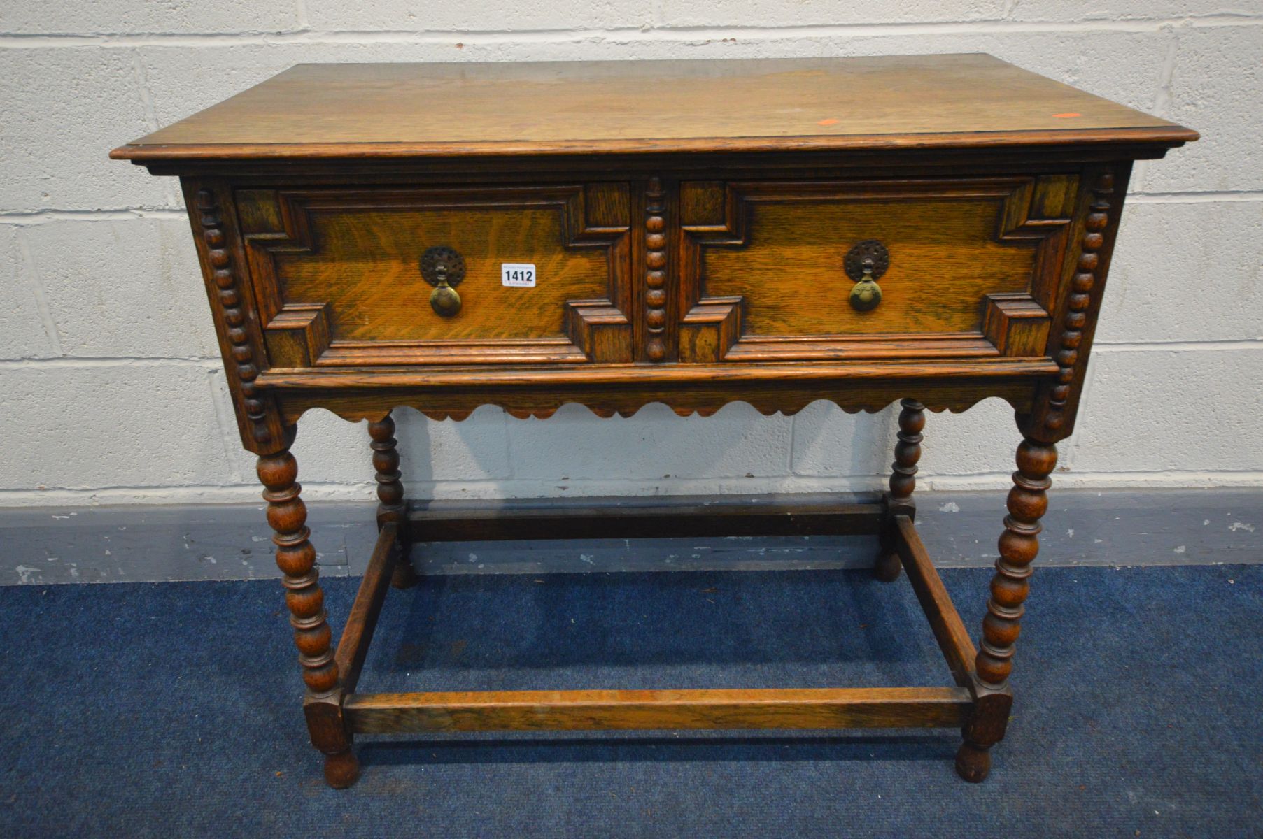 AN OAK SIDE TABLE, two drawers with geometric detail, on bobbin turned legs united by a box