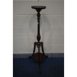 AN EDWARDIAN MAHOGANY TORCHERE STAND, the spinning circular top on a turned support, above triple