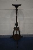 AN EDWARDIAN MAHOGANY TORCHERE STAND, the spinning circular top on a turned support, above triple