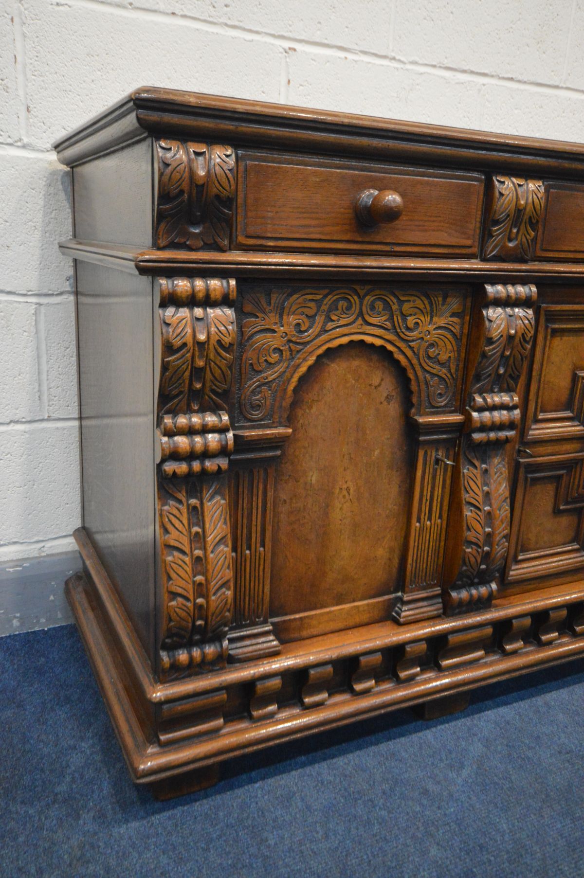 A REPRODUCTION SOLID OAK SIDEBOARD, with three drawers above two arched panelled doors flanking a - Image 2 of 4