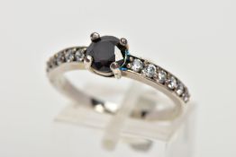 A WHITE METAL CUBIC ZIRCONIA DRESS RING, designed with a central circular cut black stone assessed