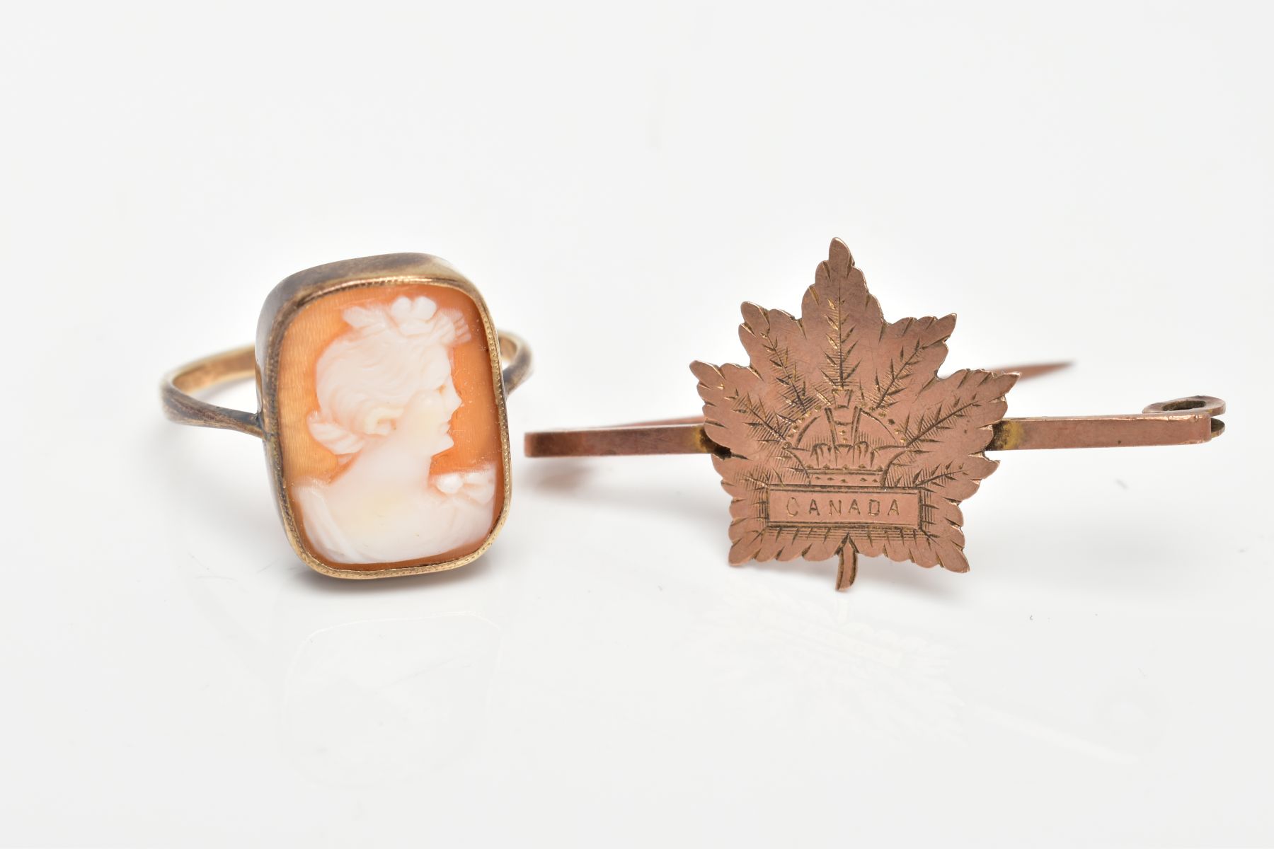 A YELLOW METAL CAMEO RING AND A YELLOW METAL BROOCH, carved shell cameo of a rectangular form,