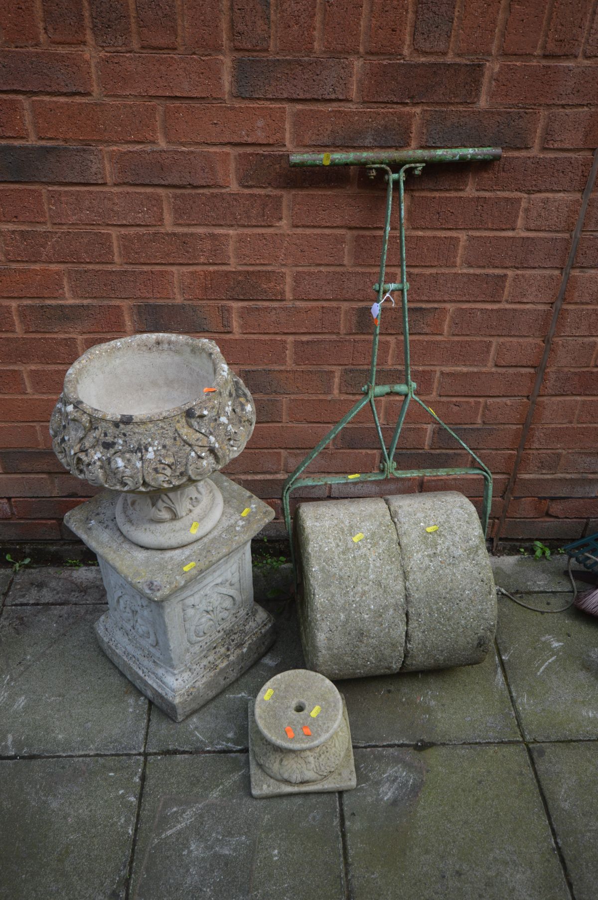 A VINTAGE METAL FRAMED COMPOSITE GARDEN ROLLER, a composite urn with fleur de lis detailing on a