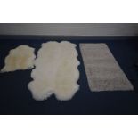 A SHEEP SKIN RUG, stamped Axminster, 107cm x 108cm, a smaller sheep skin rug, and another rug (3)