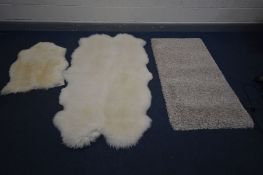 A SHEEP SKIN RUG, stamped Axminster, 107cm x 108cm, a smaller sheep skin rug, and another rug (3)