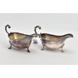 TWO SILVER GRAVY BOATS, each of a plain polished design, gadrooned rim, scroll detailed handle,
