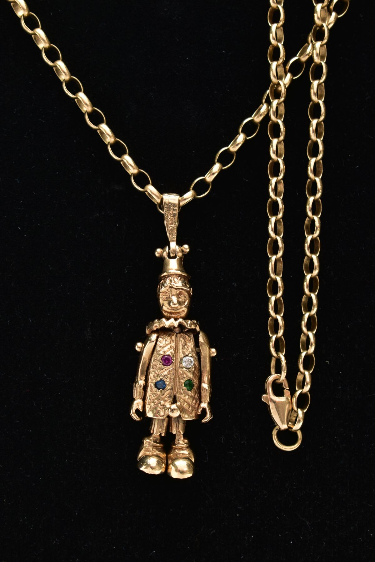 A 9CT GOLD CLOWN PENDANT AND CHAIN, the articulated clown set with four stones to the body, fitted