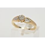 A 9CT GOLD DIAMOND RING, designed with a central illusion set round brilliant cut diamond, flanked