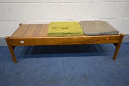 A 1960'S TEAK BENCH/COFFEE TABLE, the triple reversable inserts with cushion seat pads upholstered