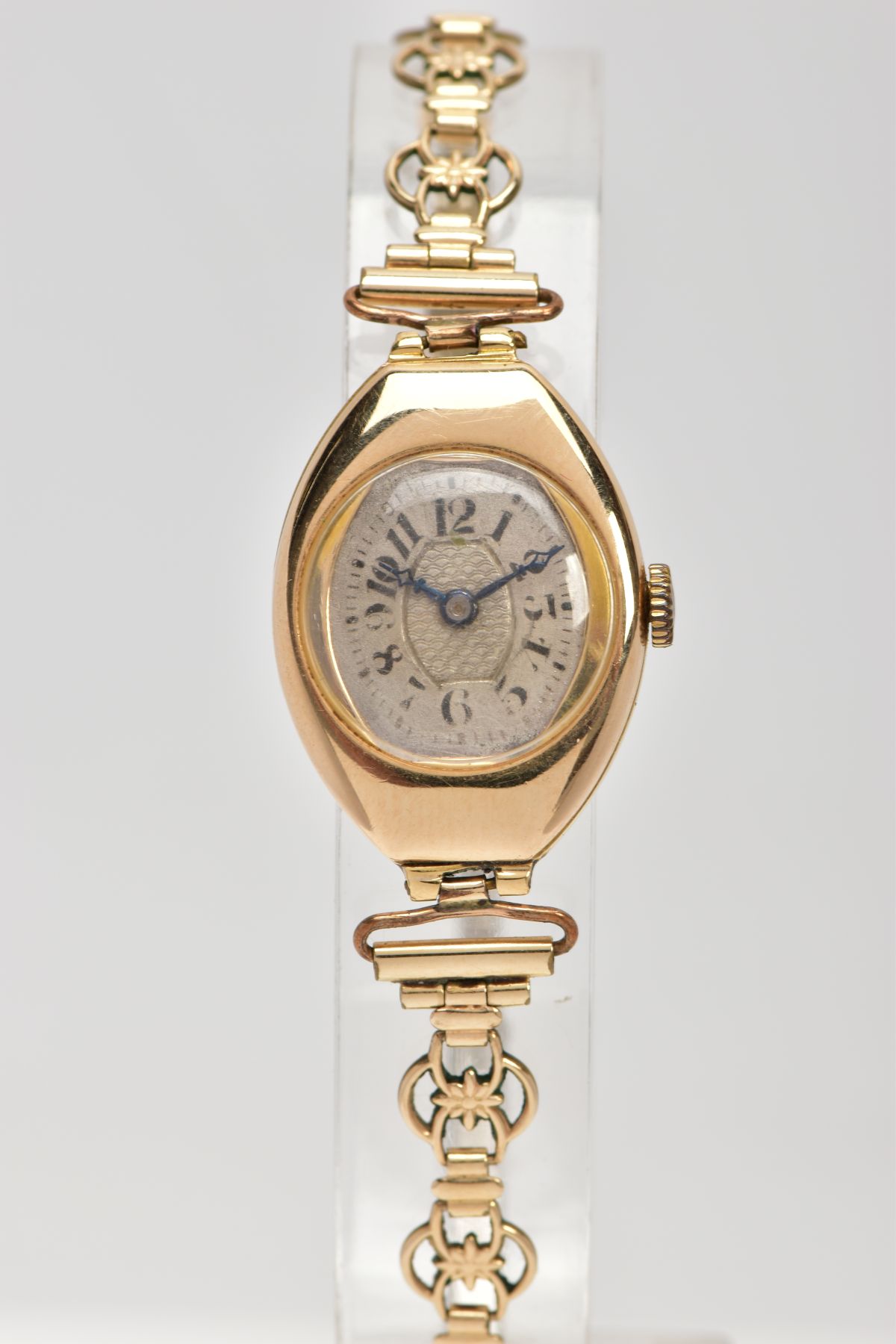 A LADY'S 18CT GOLD WRISTWATCH, hand wound movement, curved silver dial, Arabic numerals, blue hands,