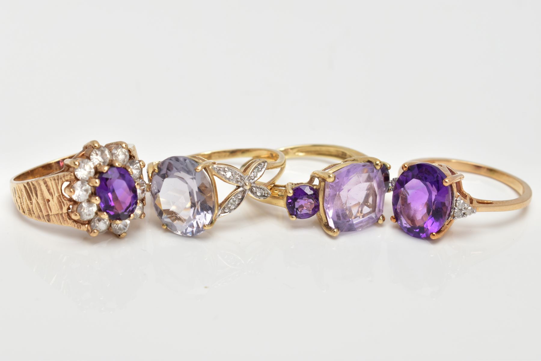 FOUR AMETHYST DRESS RINGS, two set with oval cut amethysts with single cut diamond detailed - Image 2 of 3