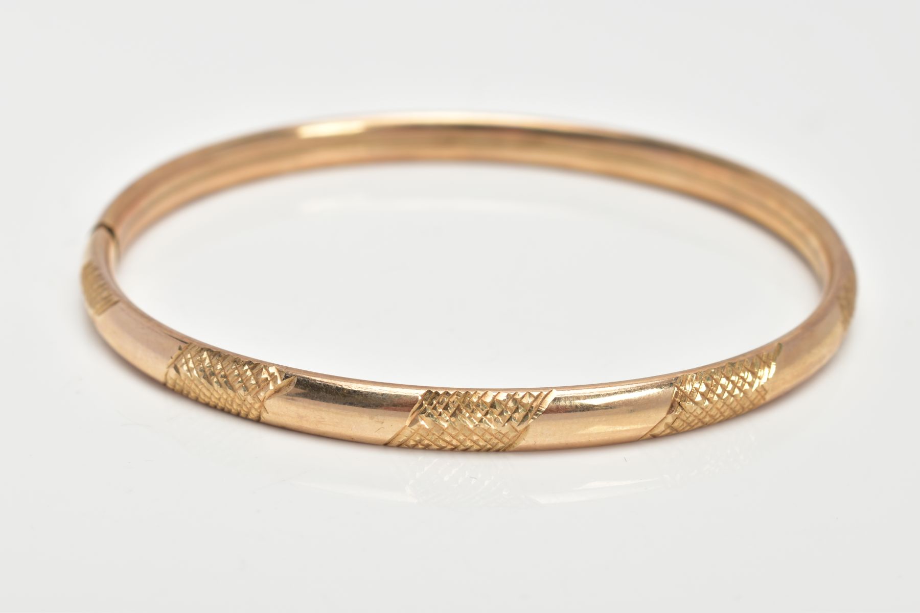 A 9CT GOLD HOLLOW BANGLE, textured design, integrated clasp, hallmarked 9ct gold Birmingham