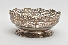 A SILVER PIERCED DISH, of a circular form with a pierced foliate rim and a vacant shield shaped