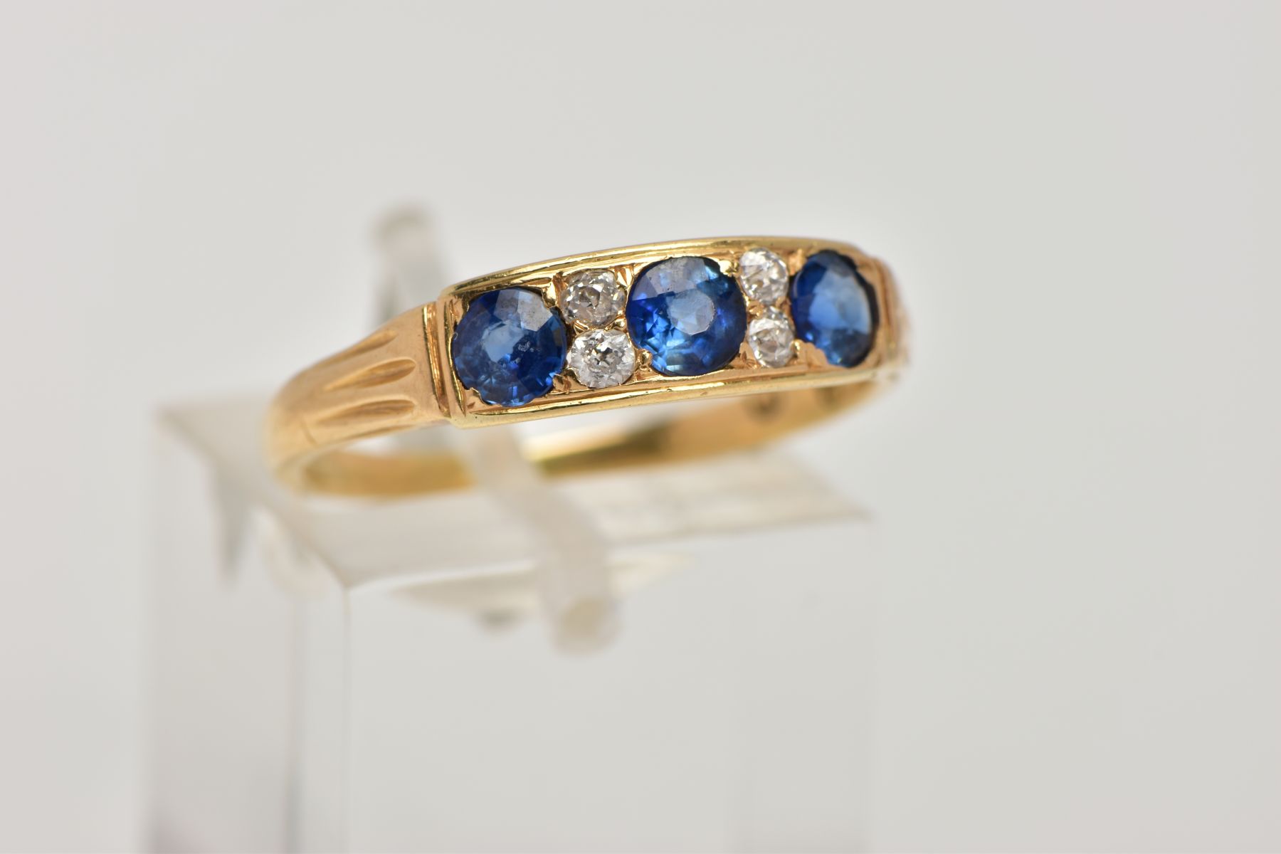 A YELLOW METAL SAPPHIRE AND DIAMOND RING, designed with a row of three circular cut blue - Image 4 of 4