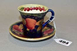 A WILLIAM MOORCROFT POMEGRANATE PATTERN COFFEE CAN AND SAUCER, dark blue ground, the coffee can of