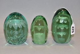 THREE VICTORIAN GREEN GLASS DUMP WEIGHTS, all three with floral/fountain and bubble inclusions,