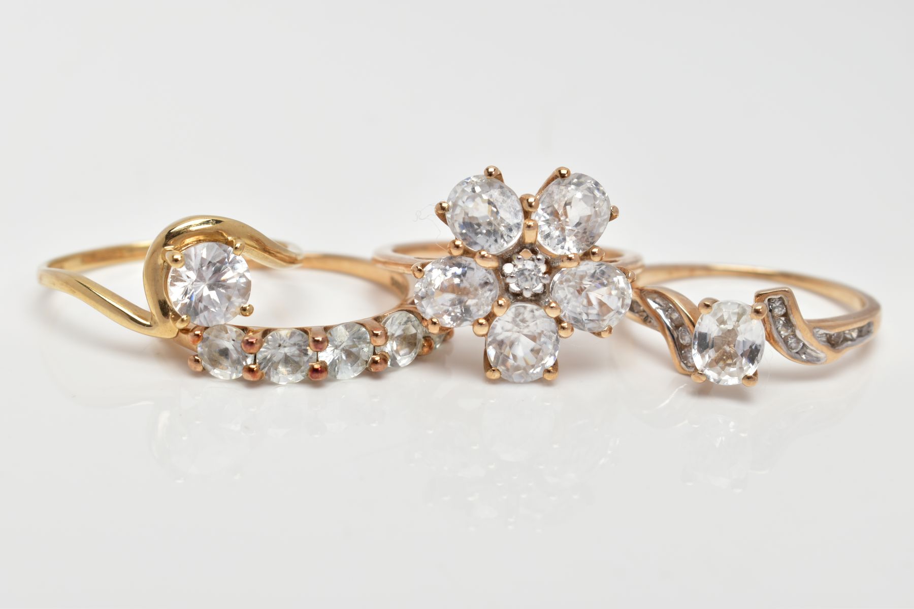 FOUR 9CT GOLD COLOURLESS ZIRCON SET DRESS RINGS, each with a 9ct gold hallmark for Birmingham,