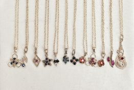 TWELVE WHITE METAL PENDANT NECKLACES, each pendant set with either sapphires, rubies and/or