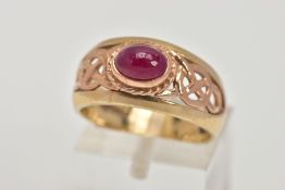 A 9CT GOLD 'CLOGAU' SIGNET RING, designed with a central oval ruby cabochon, collet mount with a