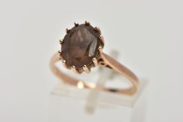 A 9CT GOLD SMOKEY QUARTZ DRESS RING, designed with a twelve claw set, oval cut Smokey quartz,