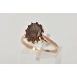 A 9CT GOLD SMOKEY QUARTZ DRESS RING, designed with a twelve claw set, oval cut Smokey quartz,