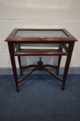 A MAHOGANY BIJOUTERIE TABLE, with bevelled edge glass lid enclosing a mirrored interior, on square