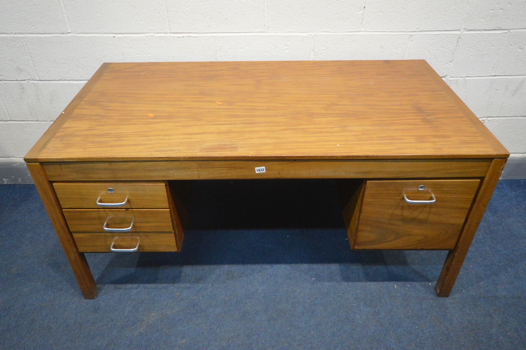 A MID 20TH CENTURY TEAK OFFICE DESK, a bank of three drawers and deep drawer opposing, width 153cm x