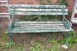 A DISTRESSED GARDEN BENCH 108cm wide with metal scrolled ends and wooden slats