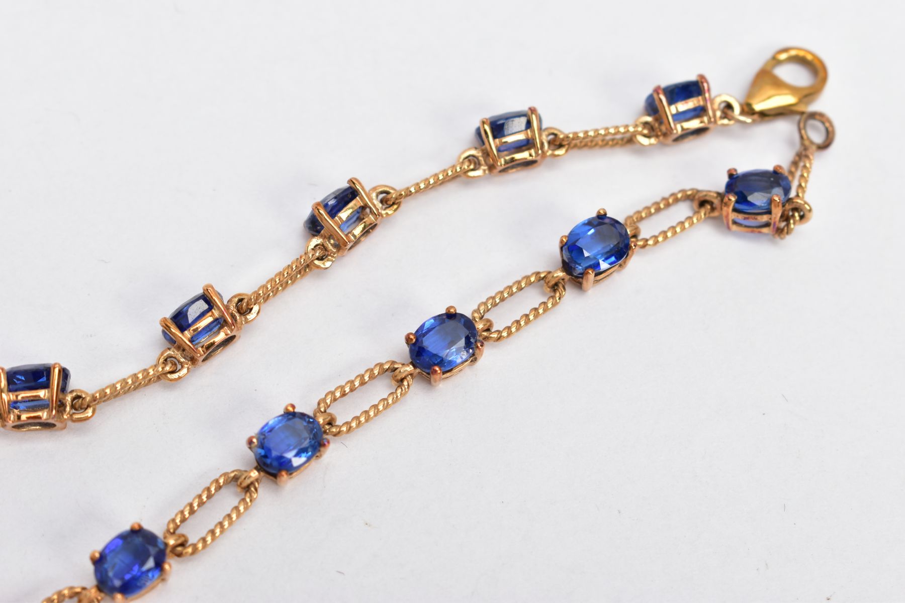 A 9CT GOLD KYANITE SET LINE BRACELET, designed with thirteen oval cut kyanites, interspaced with - Image 3 of 3