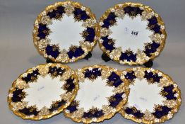 A SET OF FIVE EARLY 20TH CENTURY COALPORT DESSERT PLATES, wavy and moulded foliate gilt rims, blue
