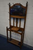 AN ARTS AND CRAFTS OAK HALL STAND, with eight hooks, and a bevelled edge mirror, width 76cm x