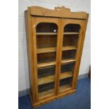 A PINE GLAZED TWO DOOR BOOKCASE, with four fixed shelves, width 96cm x depth 34cm x height 169cm