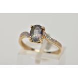 A 9CT GOLD TOPAZ AND DIAMOND DRESS RING, designed with a four claw set, oval cut topaz (mystic