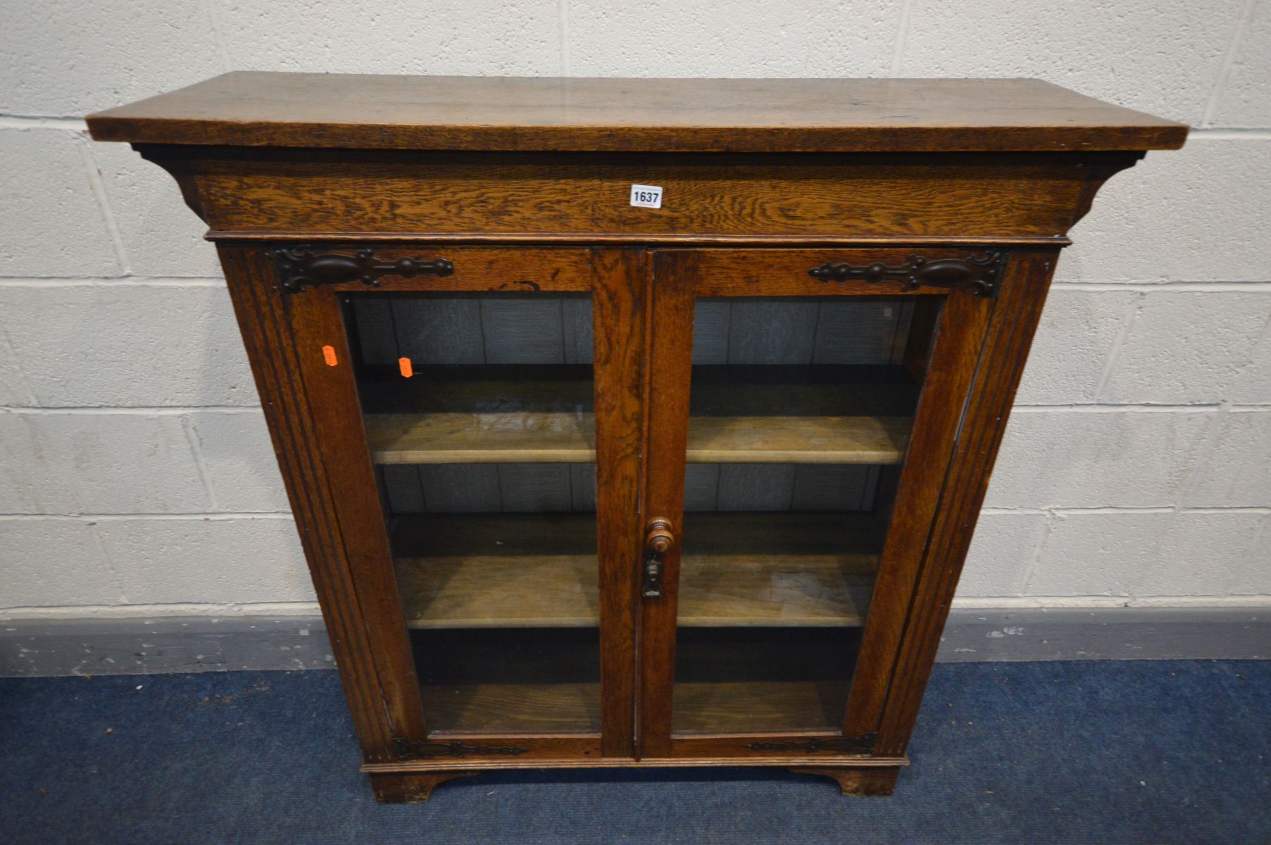 AN ARTS AND CRAFTS OAK BOOKCASE, oversized top, double glazed door enclosing two shelves, width