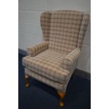 A TARTAN UPHOLSTERED WING BACK ARMCHAIR, on beech legs