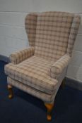 A TARTAN UPHOLSTERED WING BACK ARMCHAIR, on beech legs