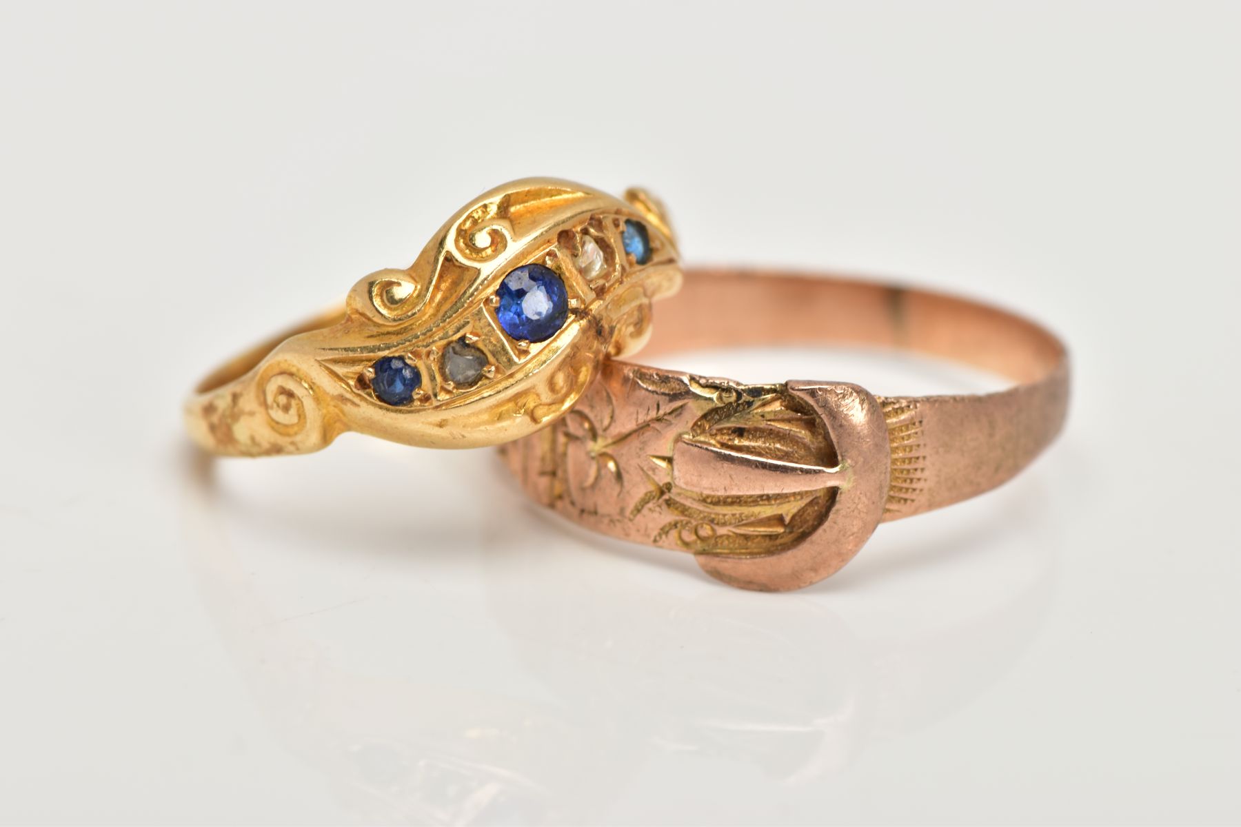 TWO EARLY 20TH CENTURY GOLD RINGS, the first designed as a curved row of two graduated circular