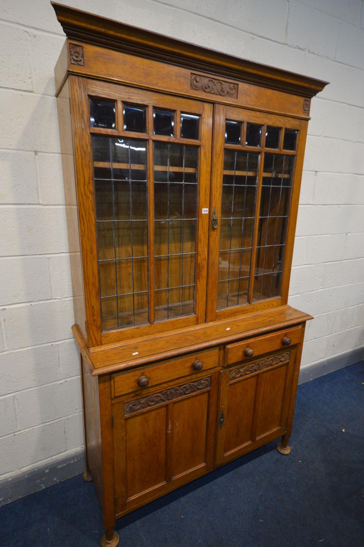 AN EARLY 20TH CENTURY ARTS AND CRAFTS OAK TWO DOOR LEAD GLAZED BOOKCASE, with two drawers, over - Image 2 of 5