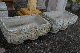 A PAIR OF COMPOSITE RECTANGULAR PLANTERS, with foliate and putto decoration, width 56cm x depth 35cm