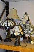 FIVE MODERN METAL BASED TABLE LAMPS, four with leaded and coloured glass shades, and one with a